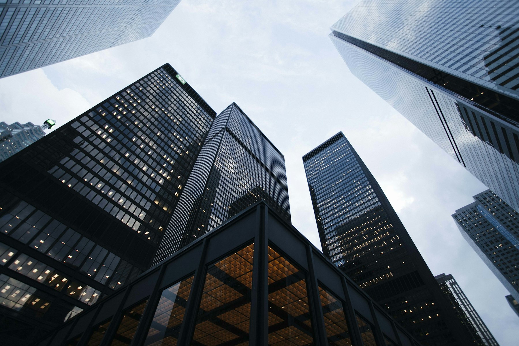 A glass tower seen from below against a pale sky